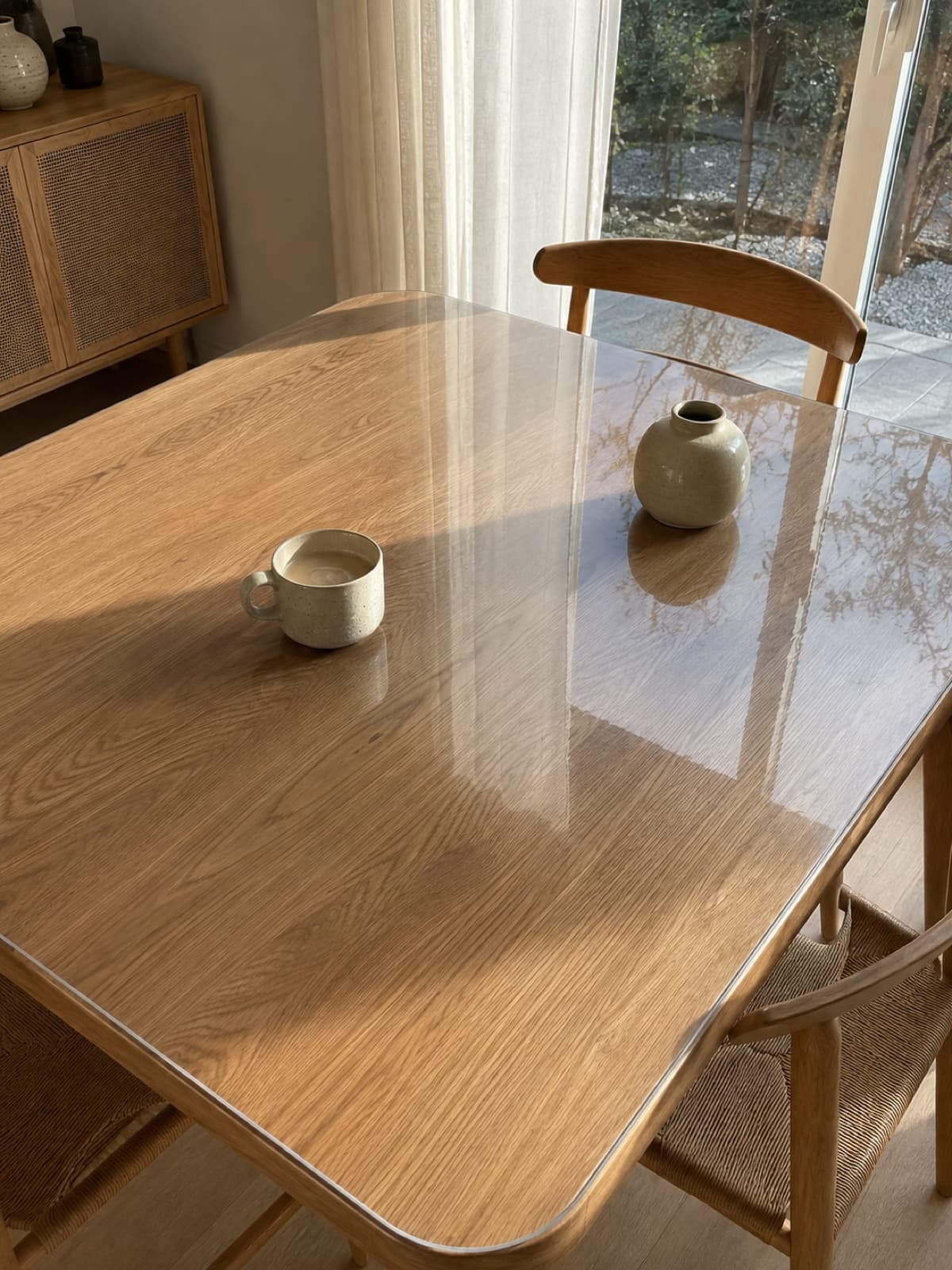 Transparante beschermmat op een eiken tafel — de houtnerf blijft zichtbaar