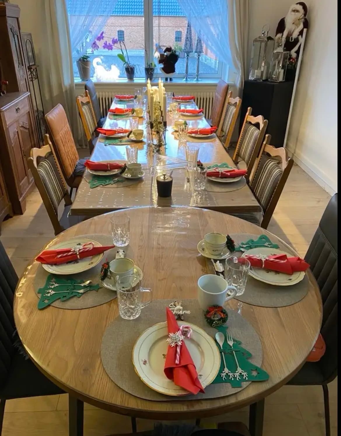 Feestelijk gedekte, uitgeschoven eiken tafel; het blad onder de rode servetten wordt beschermd door een transparante mat