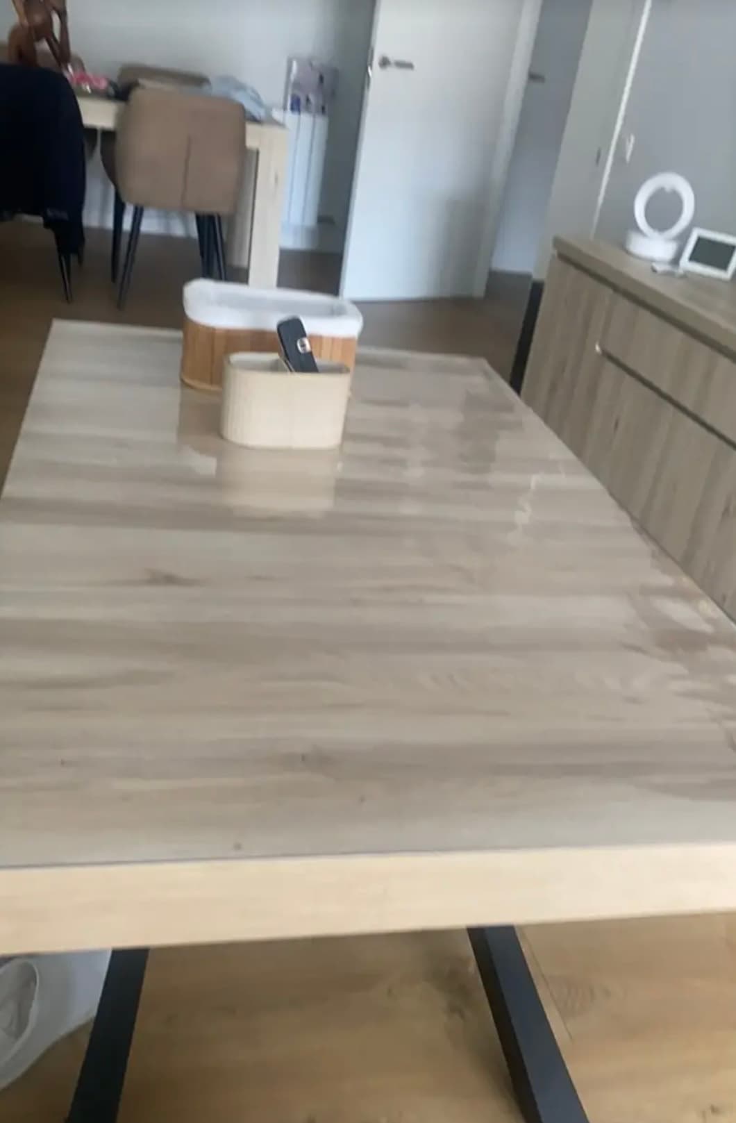 Lichte tafel in de woonkamer met houten bakjes; de mat weerkaatst het licht van het raam